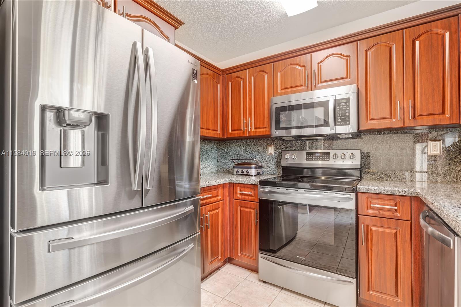 16323 Southwest 97th Street Miami, FL 33196 - Photo 9 of 44 a kitchen with stainless steel appliances granite countertop a refrigerator stove and sink