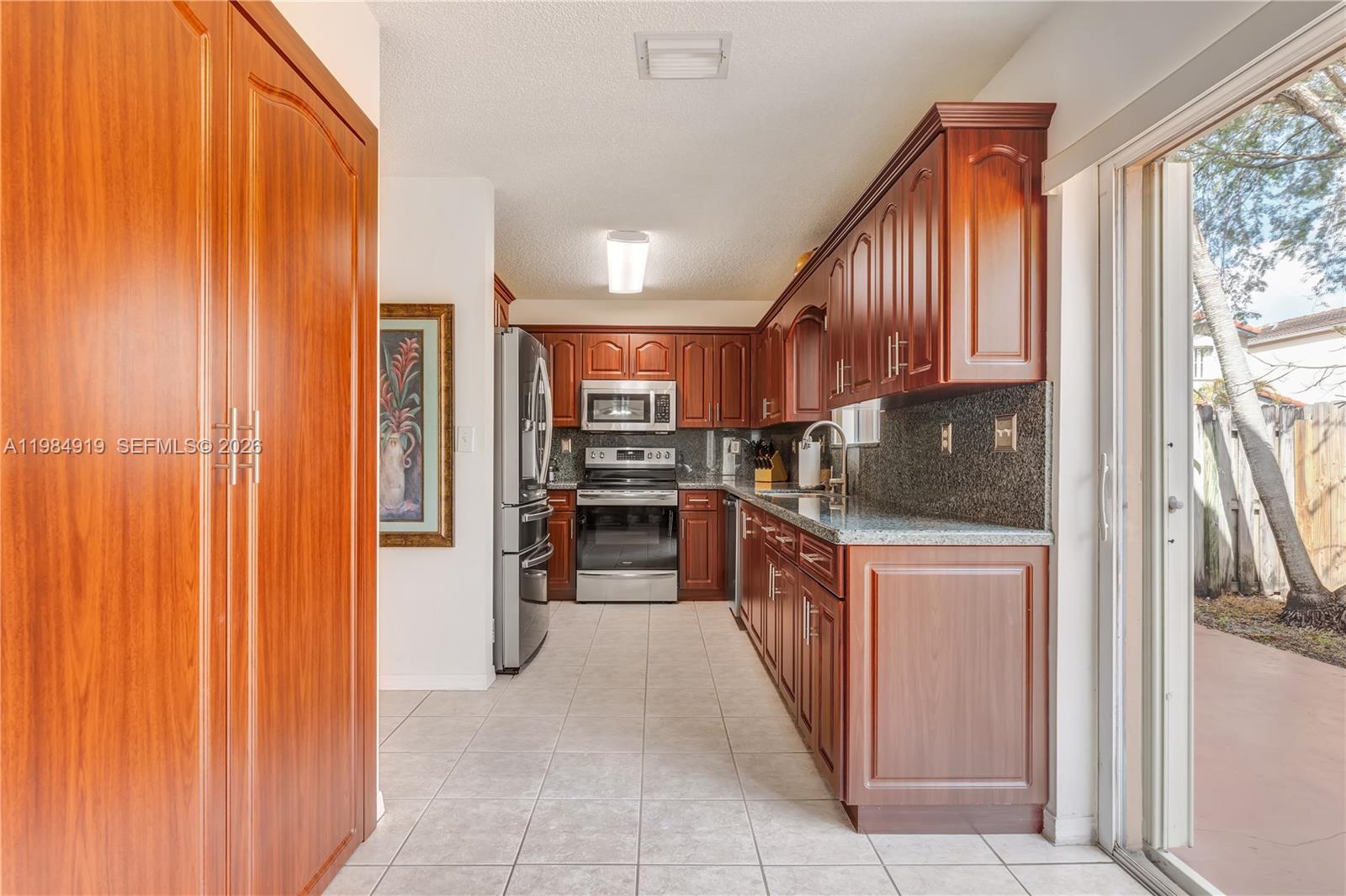 16323 Southwest 97th Street Miami, FL 33196 - Photo 10 of 44 a kitchen with stainless steel appliances a refrigerator and wooden cabinets