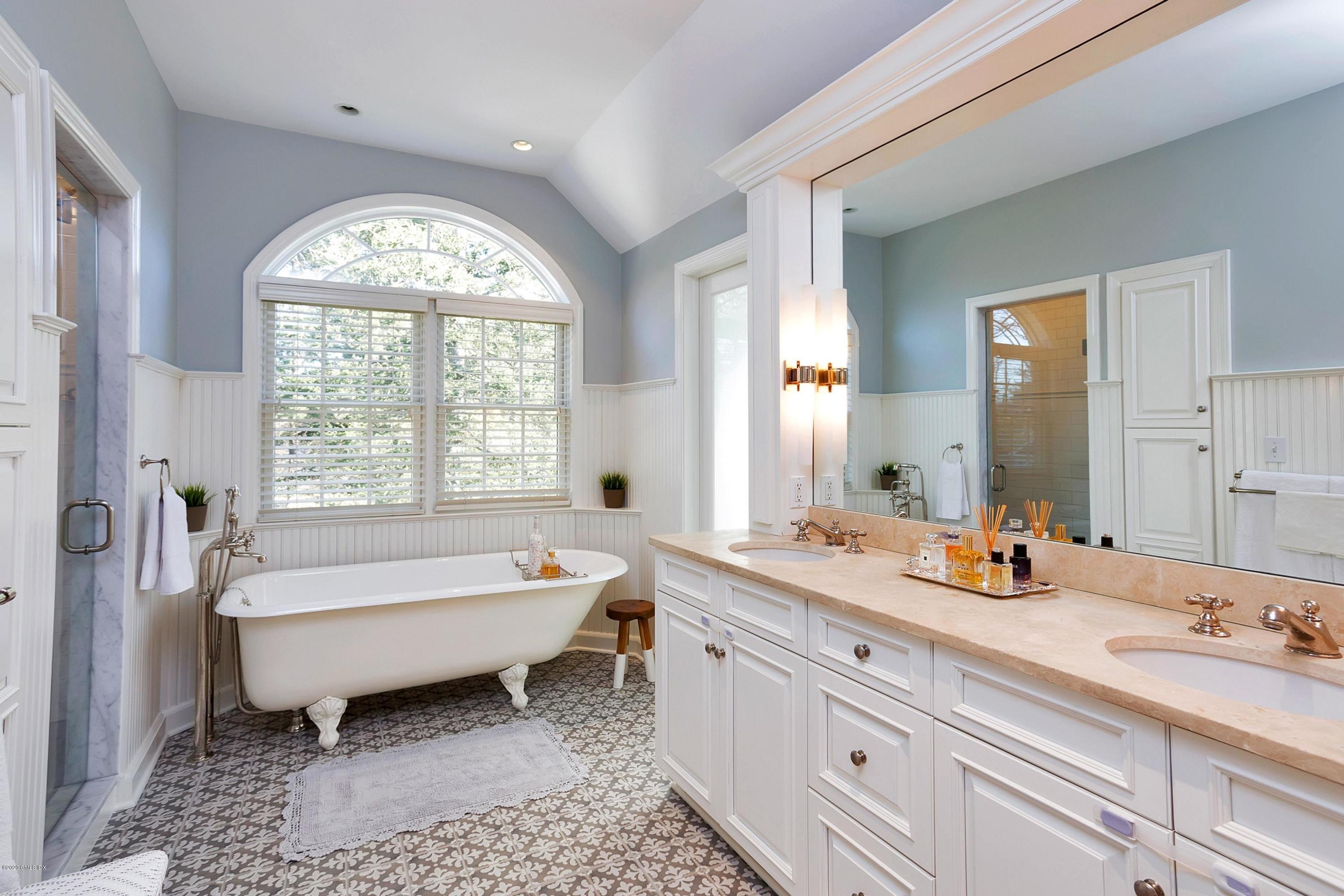 111 Lockwood Road Riverside, CT 06878 - Photo 18 of 35 a spacious bathroom with a double vanity sink a mirror and a bathtub