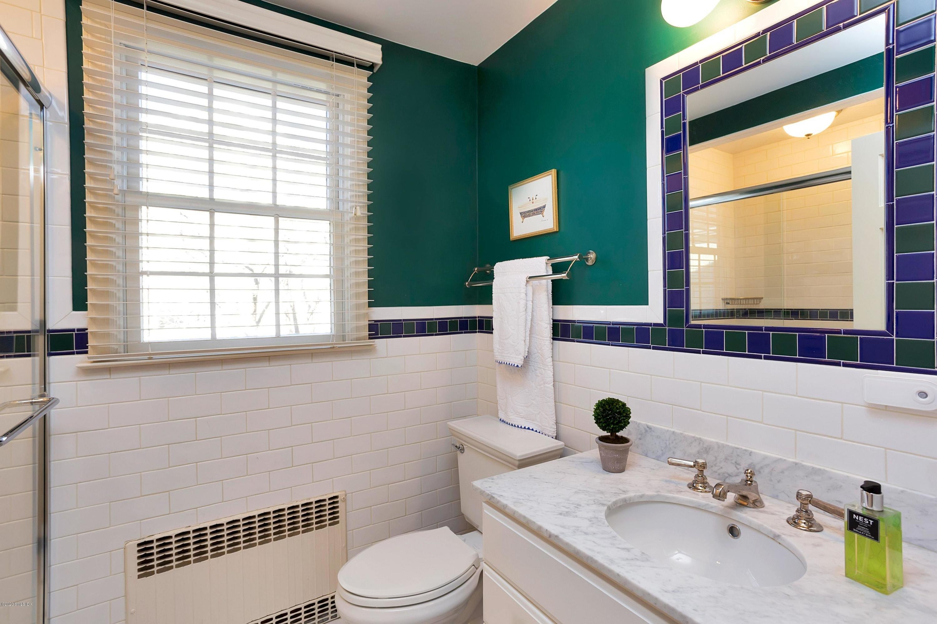 111 Lockwood Road Riverside, CT 06878 - Photo 21 of 35 a bathroom with a granite countertop sink toilet a mirror and window
