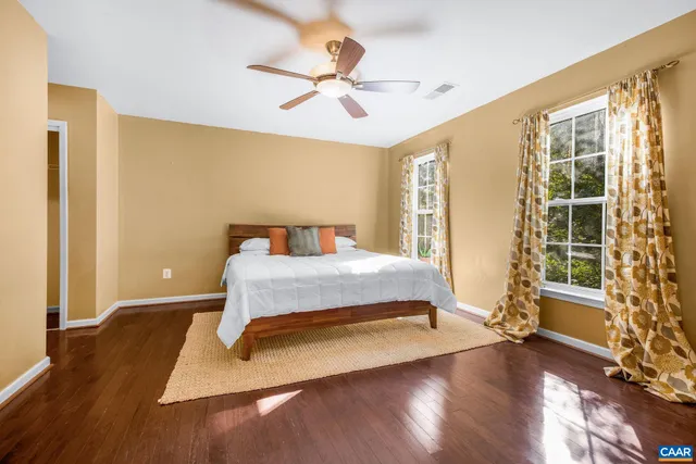 a spacious bedroom with a bed and wooden floor