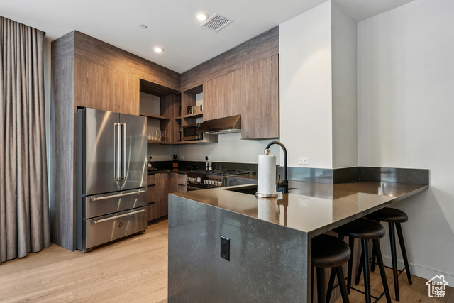 2417 West High Mountain Road, Unit 2202 Park City, UT 84098 - Photo 11 of 28 Kitchen featuring a kitchen breakfast bar, light wood-type flooring, kitchen peninsula, high end appliances, and extractor fan