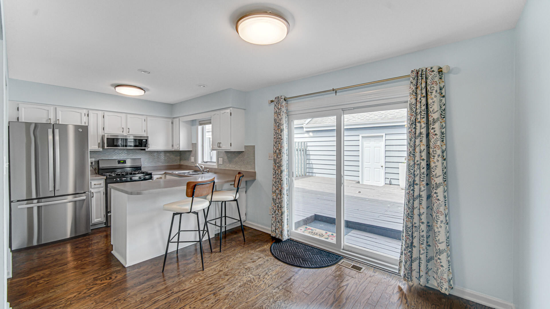 771 Kenmare Parkway Crown Point, IN 46307 - Photo 2 of 20 a kitchen with a refrigerator a microwave oven a sink and a dining table with wooden floor