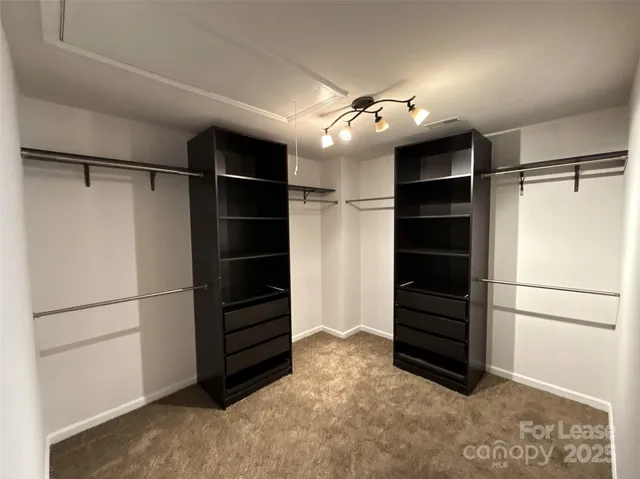 a view of walk in closet with empty racks