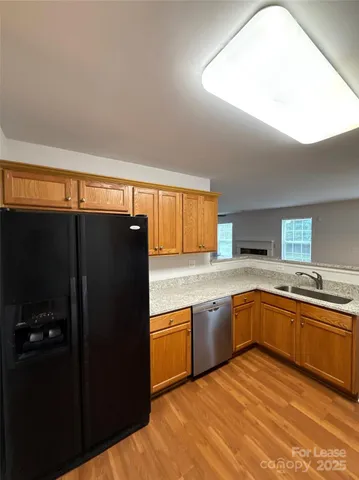 a kitchen with granite countertop a refrigerator and a sink