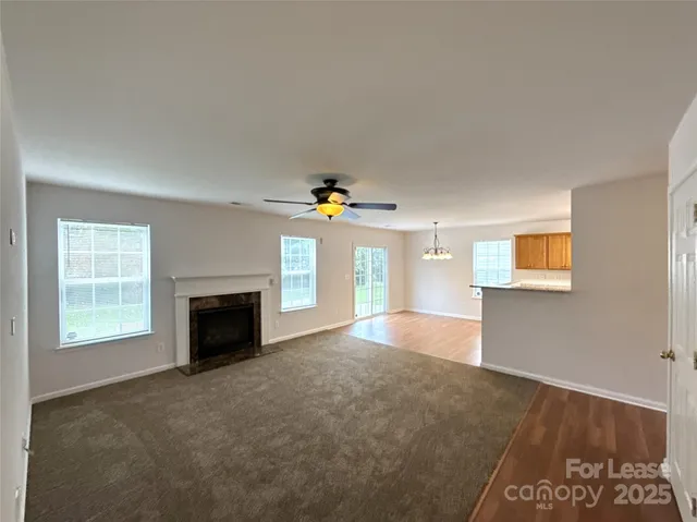 an empty room with windows and fireplace
