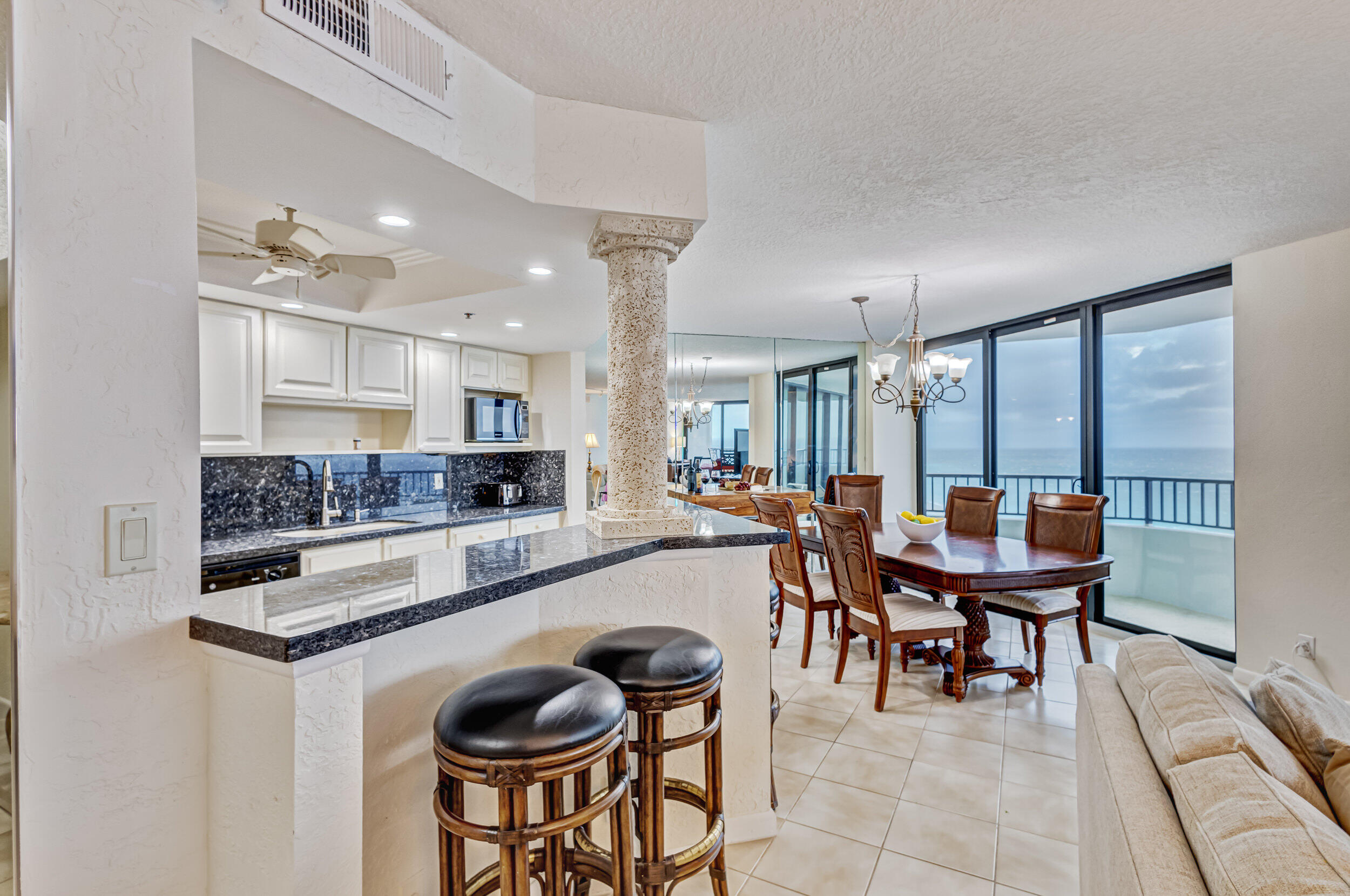 600 Ocean Drive, Unit 11A Juno Beach, FL 33408 - Photo 16 of 51 a kitchen with stainless steel appliances granite countertop a table chairs sink and cabinets
