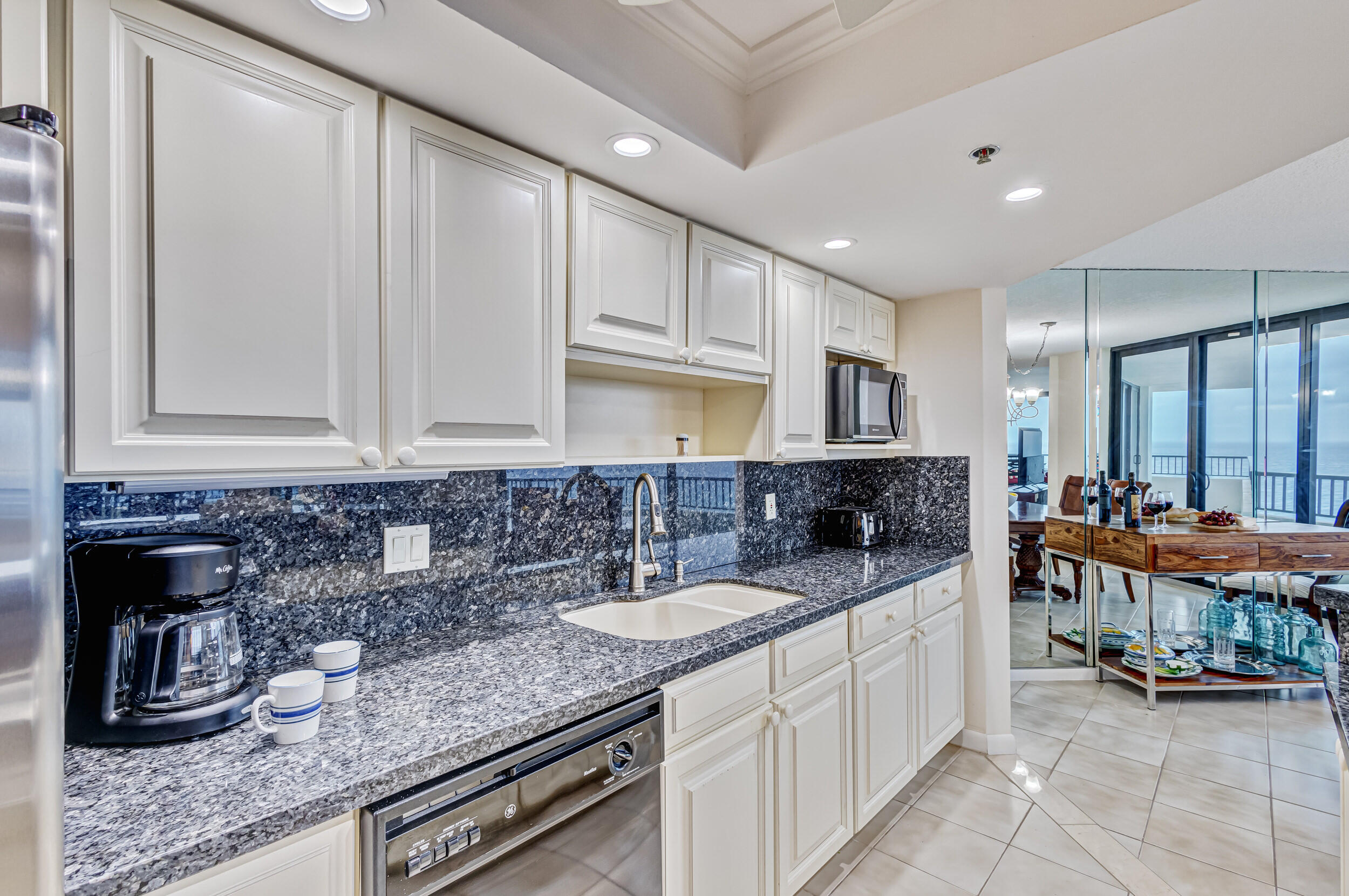 600 Ocean Drive, Unit 11A Juno Beach, FL 33408 - Photo 21 of 51 a kitchen with stainless steel appliances granite countertop a sink and cabinets