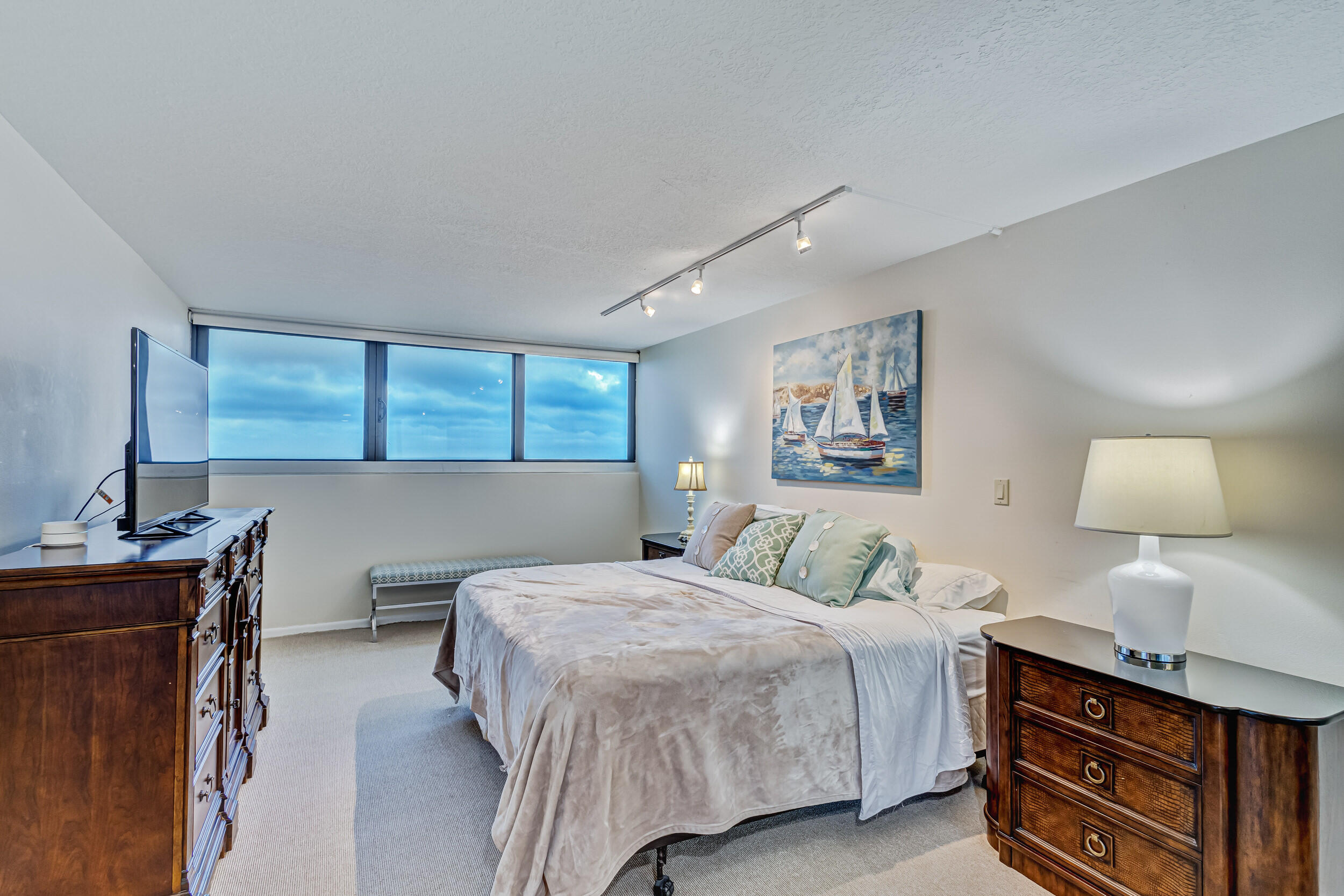 600 Ocean Drive, Unit 11A Juno Beach, FL 33408 - Photo 25 of 51 a bedroom with a bed and a lamp on dresser