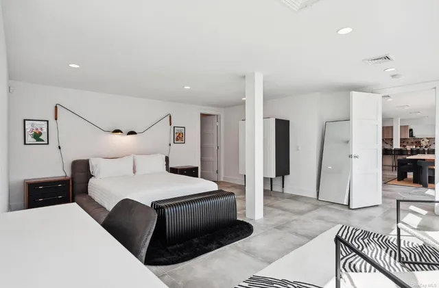 a bedroom with a bed a table and large window