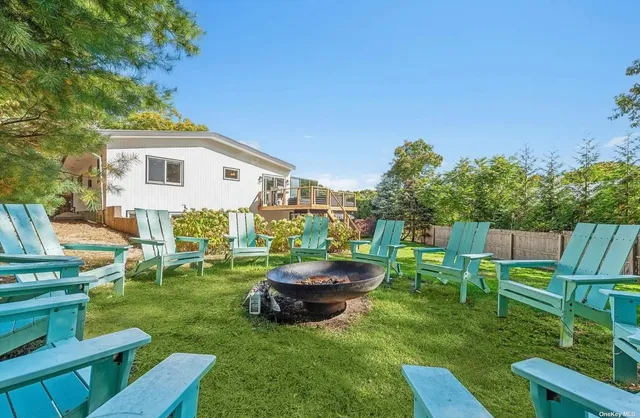 a view of a patio with table and chairs and potted plants with wooden floor and fence