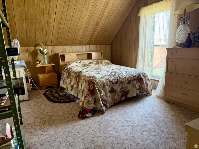 85 South Main Street Woodruff, UT 84086 - Photo 9 of 14 Attic bedroom featuring angled wood-paneled walls and a window with sheer curtains