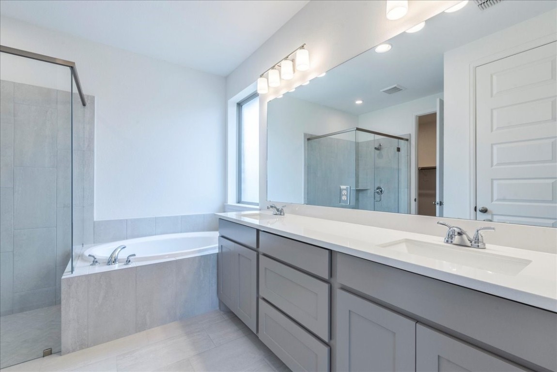 164 Kimble Creek Loop Kyle, TX 78640 - Photo 15 of 35 a bathroom with a tub a sink shower and mirror