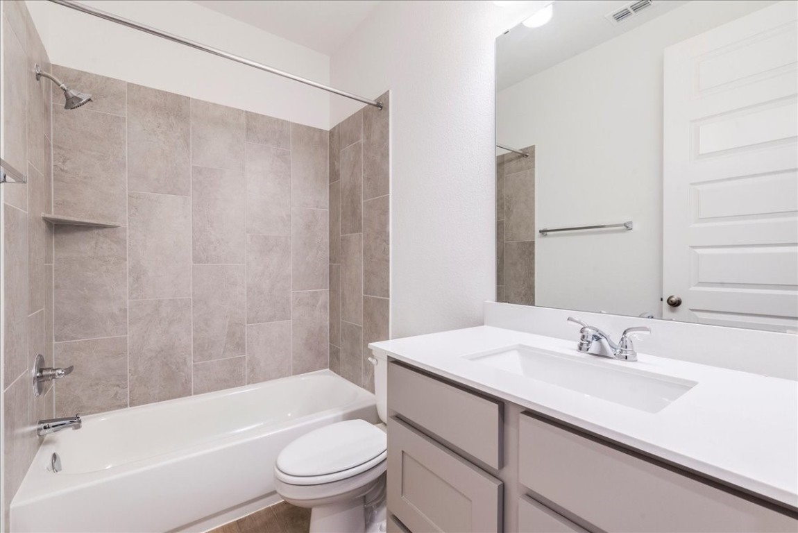 164 Kimble Creek Loop Kyle, TX 78640 - Photo 24 of 35 a bathroom with a granite countertop sink a toilet and shower