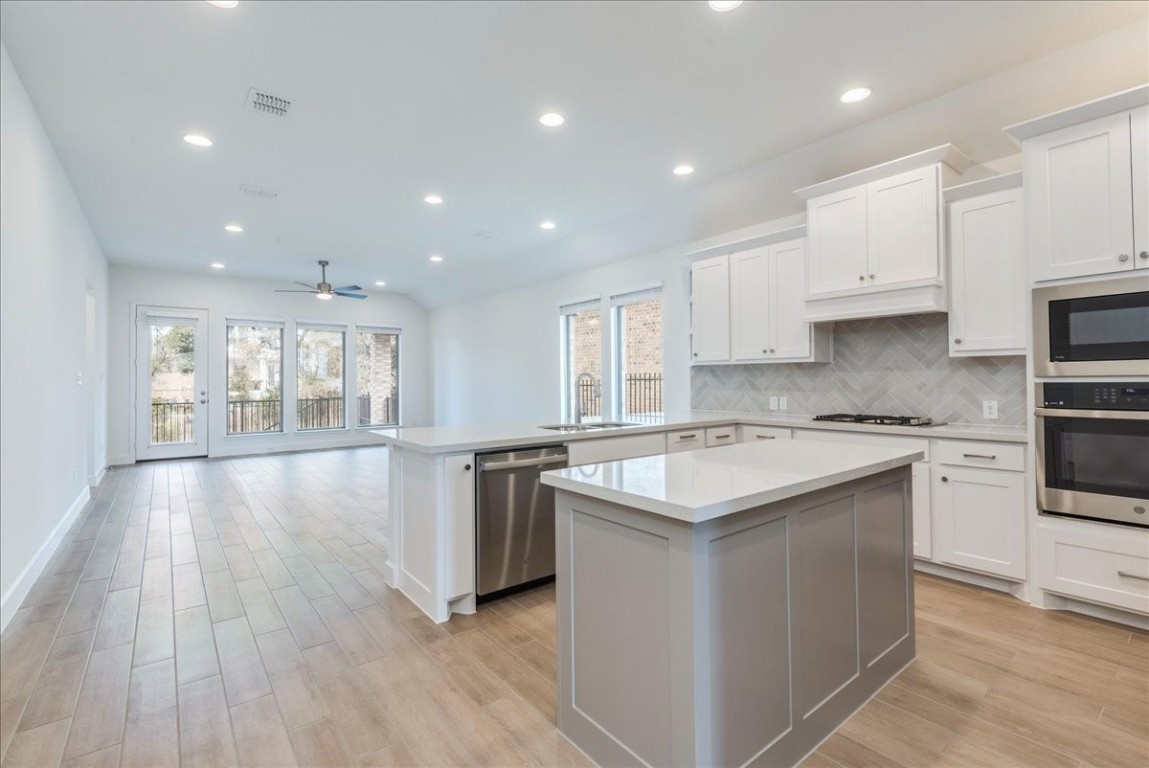 164 Kimble Creek Loop Kyle, TX 78640 - Photo 5 of 35 a kitchen with stainless steel appliances granite countertop a stove a sink and a refrigerator
