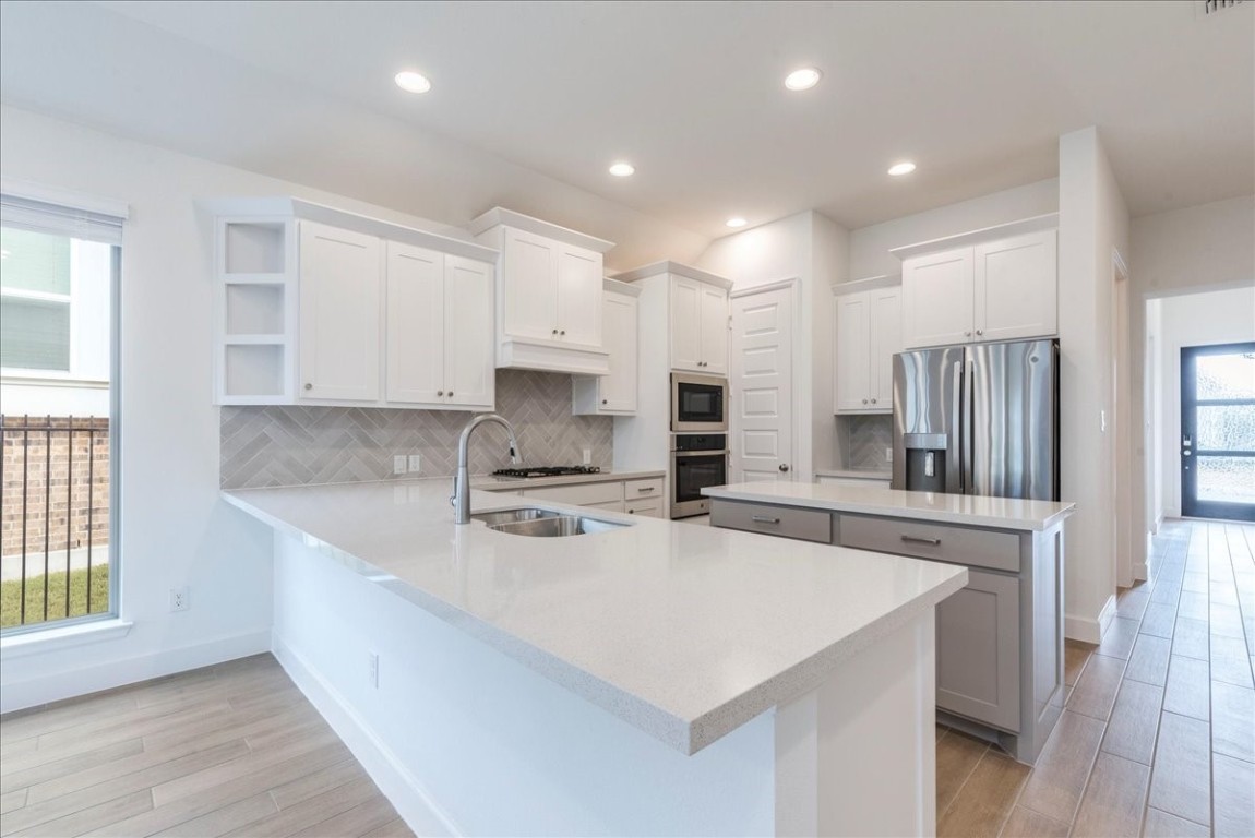 164 Kimble Creek Loop Kyle, TX 78640 - Photo 7 of 35 a kitchen with stainless steel appliances a sink a stove a refrigerator and cabinets