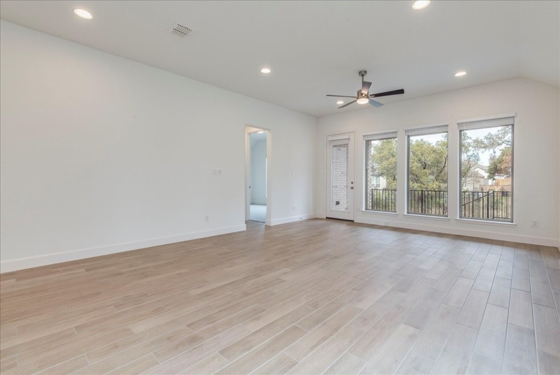 164 Kimble Creek Loop Kyle, TX 78640 - Photo 10 of 35 an empty room with wooden floor and windows