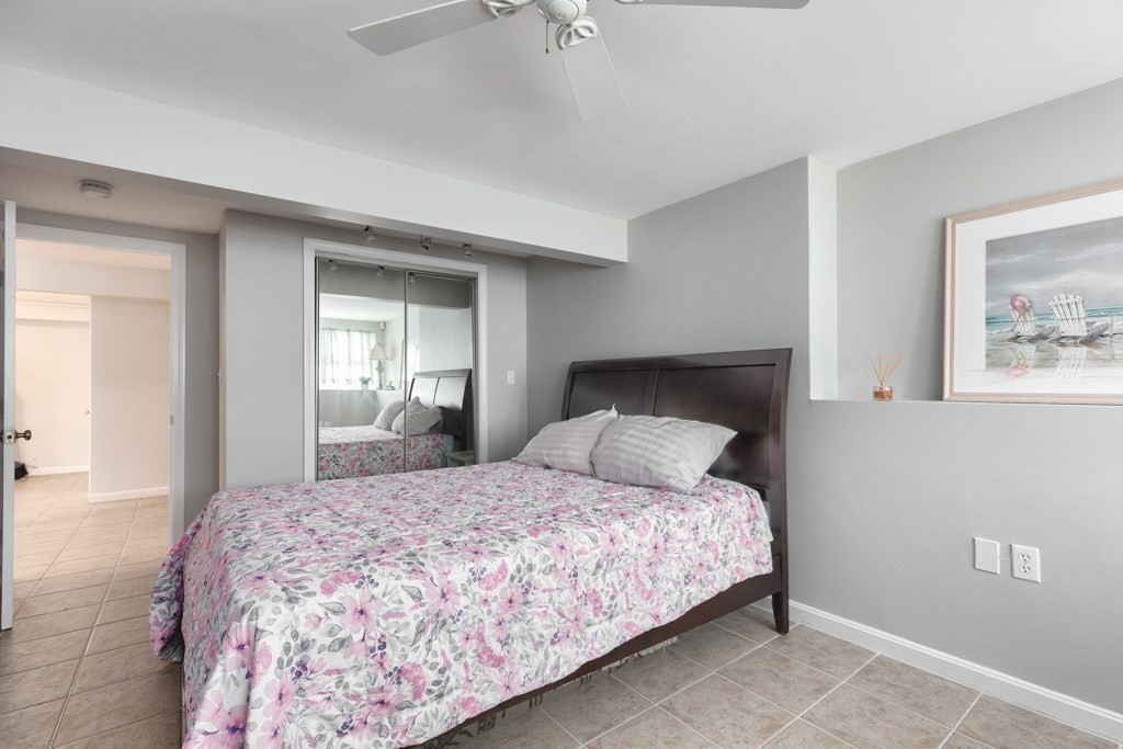 175 Rice Avenue Revere, MA 02151 - Photo 23 of 30 a bedroom with a large bed and a chandelier