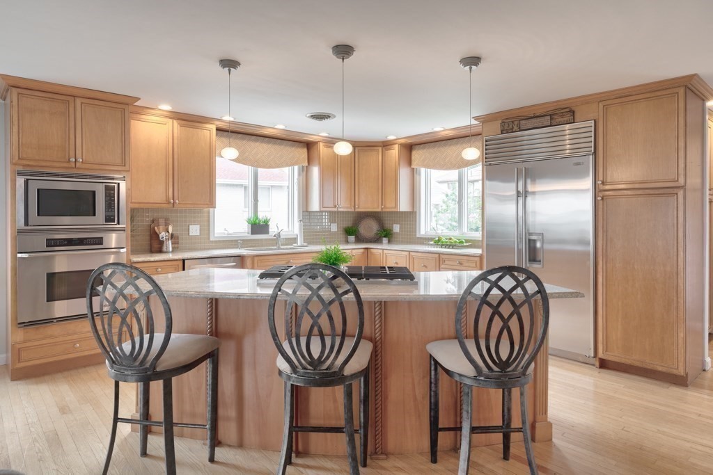 175 Rice Avenue Revere, MA 02151 - Photo 7 of 30 a kitchen with granite countertop a refrigerator dining table and chairs