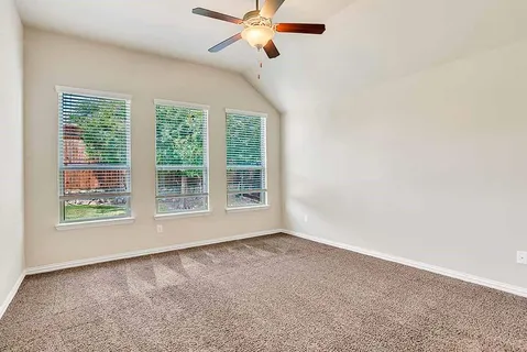 an empty room with a ceiling fan and window