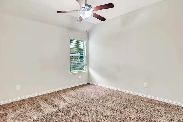 a view of a livingroom with a ceiling fan and window