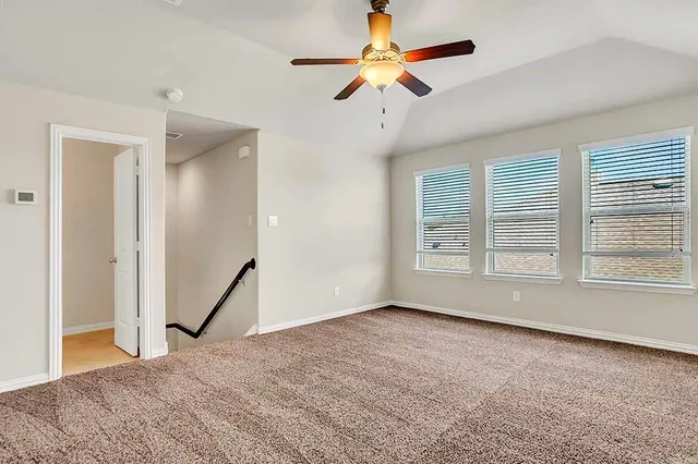 an empty room with a window and a ceiling fan