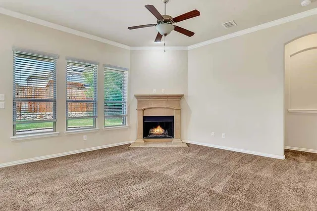 a view of empty room with fireplace and fan
