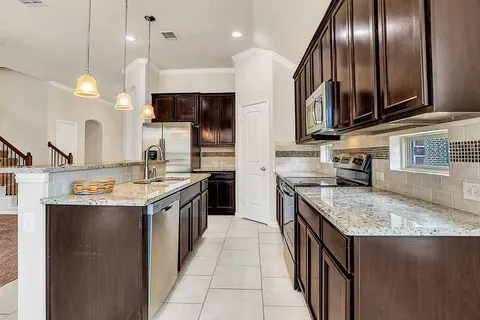 a kitchen with granite countertop a sink and a stove