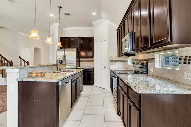 a kitchen with granite countertop a sink and a stove