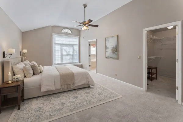 a spacious bedroom with a bed and ceiling fan