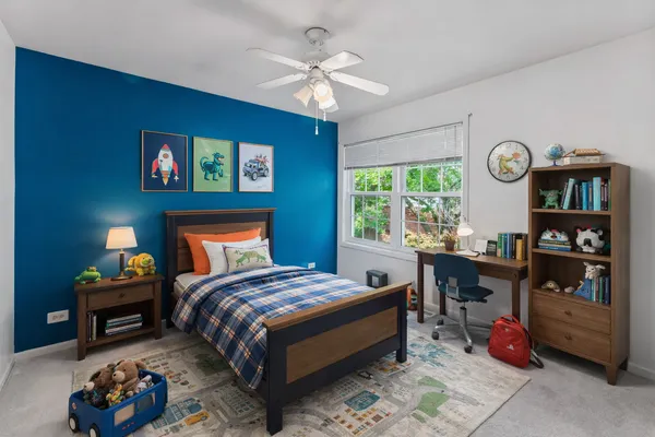 a bedroom with a bed a bookshelf and a window