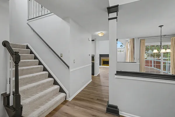 a view of a hallway with wooden floor and staircase