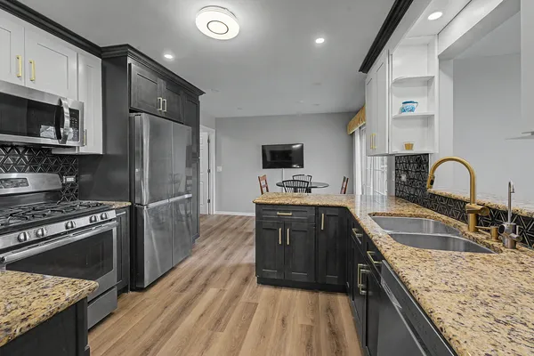 a kitchen with stainless steel appliances granite countertop a sink stove and refrigerator