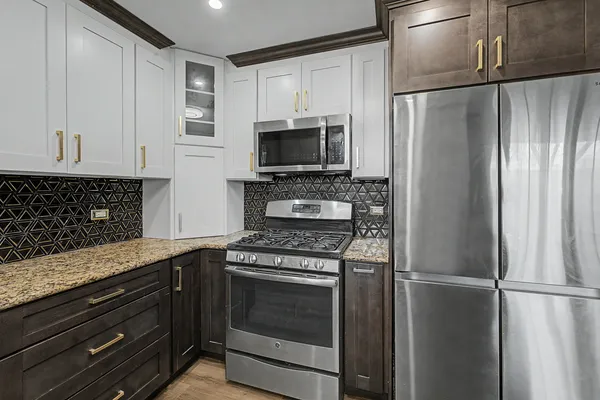 a kitchen with granite countertop a refrigerator stove and microwave
