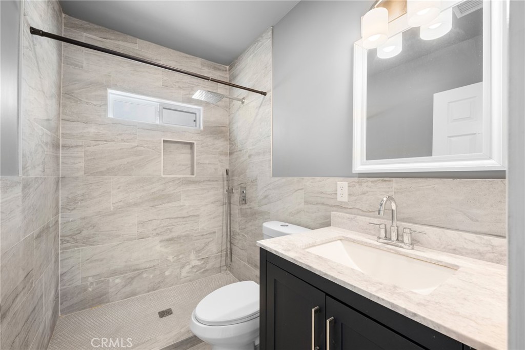 8435 Rincon Avenue Sun Valley, CA 91352 - Photo 12 of 61 a bathroom with a granite countertop sink a toilet and shower