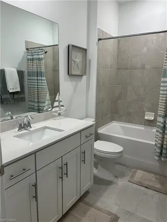 a bathroom with a toilet a sink a mirror a bathtub and vanity