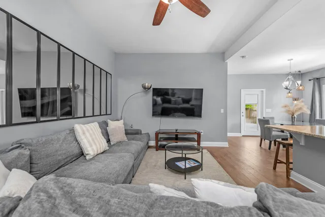 a living room with furniture ceiling fan and a flat screen tv
