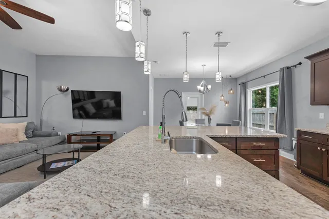 a living room with furniture a chandelier and a flat screen tv