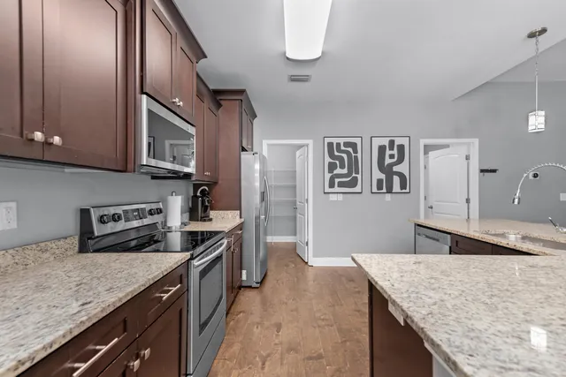 a kitchen with stainless steel appliances granite countertop a sink stove and refrigerator