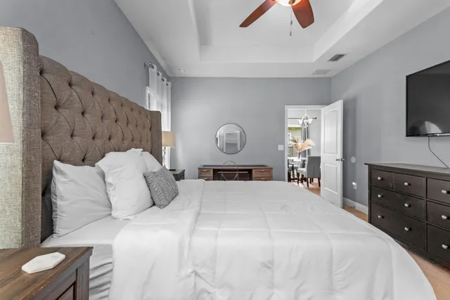 a bedroom with a bed and a flat tv screen on dresser