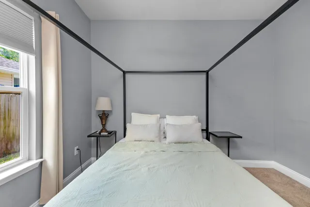 a bedroom with a bed and a large window