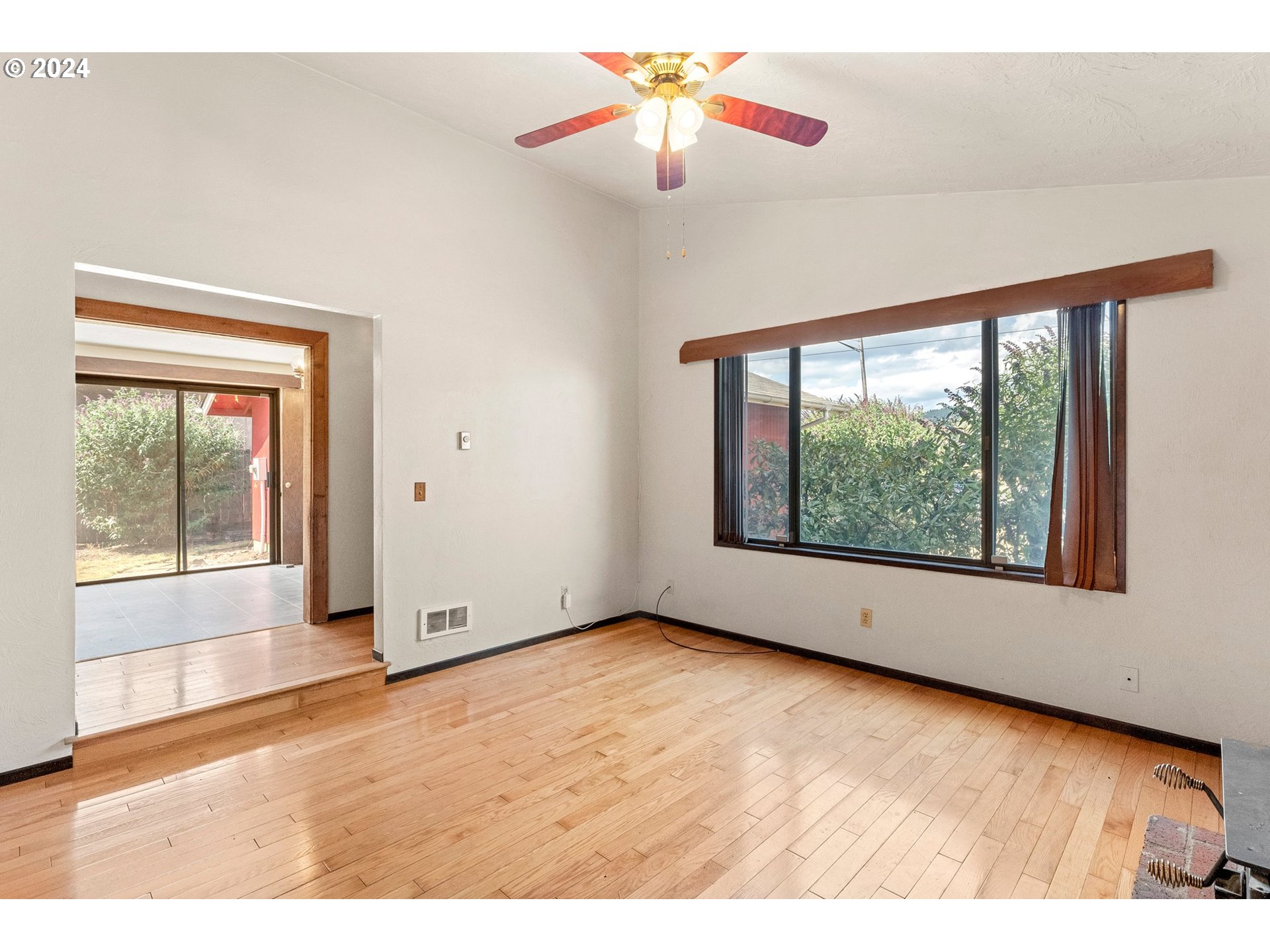 5795 High Banks Road Springfield, OR 97478 - Photo 7 of 41 a view of an empty room with wooden floor and a window