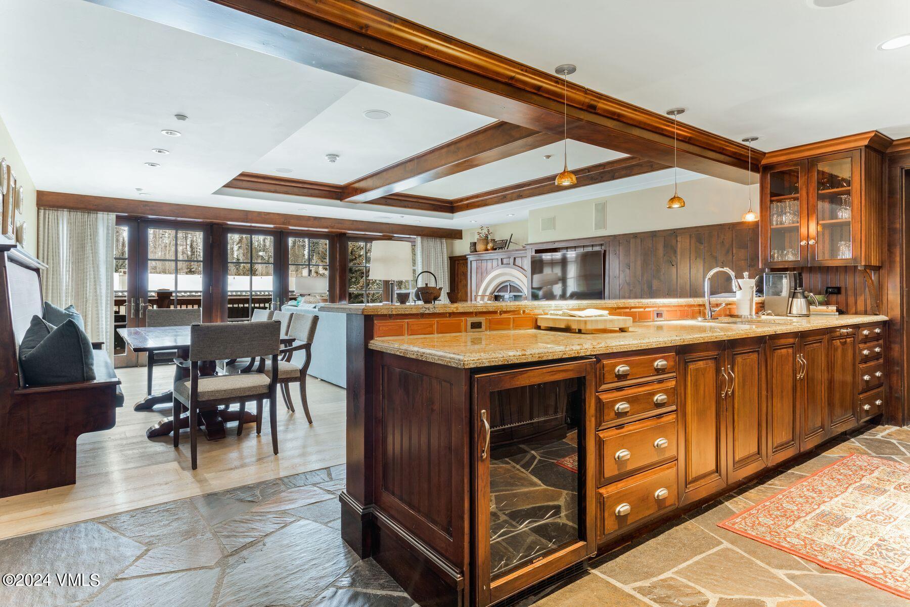 1 Willow Bridge Road, Unit 22D Vail, CO 81657 - Photo 5 of 39 a dining hall with stainless steel appliances granite countertop a stove a sink a dining table and chairs with wooden floor