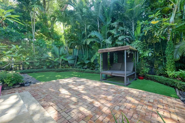 a view of a white house next to a yard