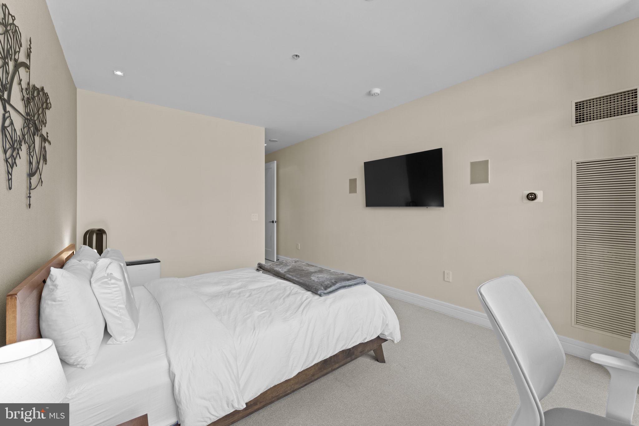 3303 Water Street Northwest, Unit 4B Washington, DC 20007 - Photo 25 of 66 a bedroom with a bed tv and a chair