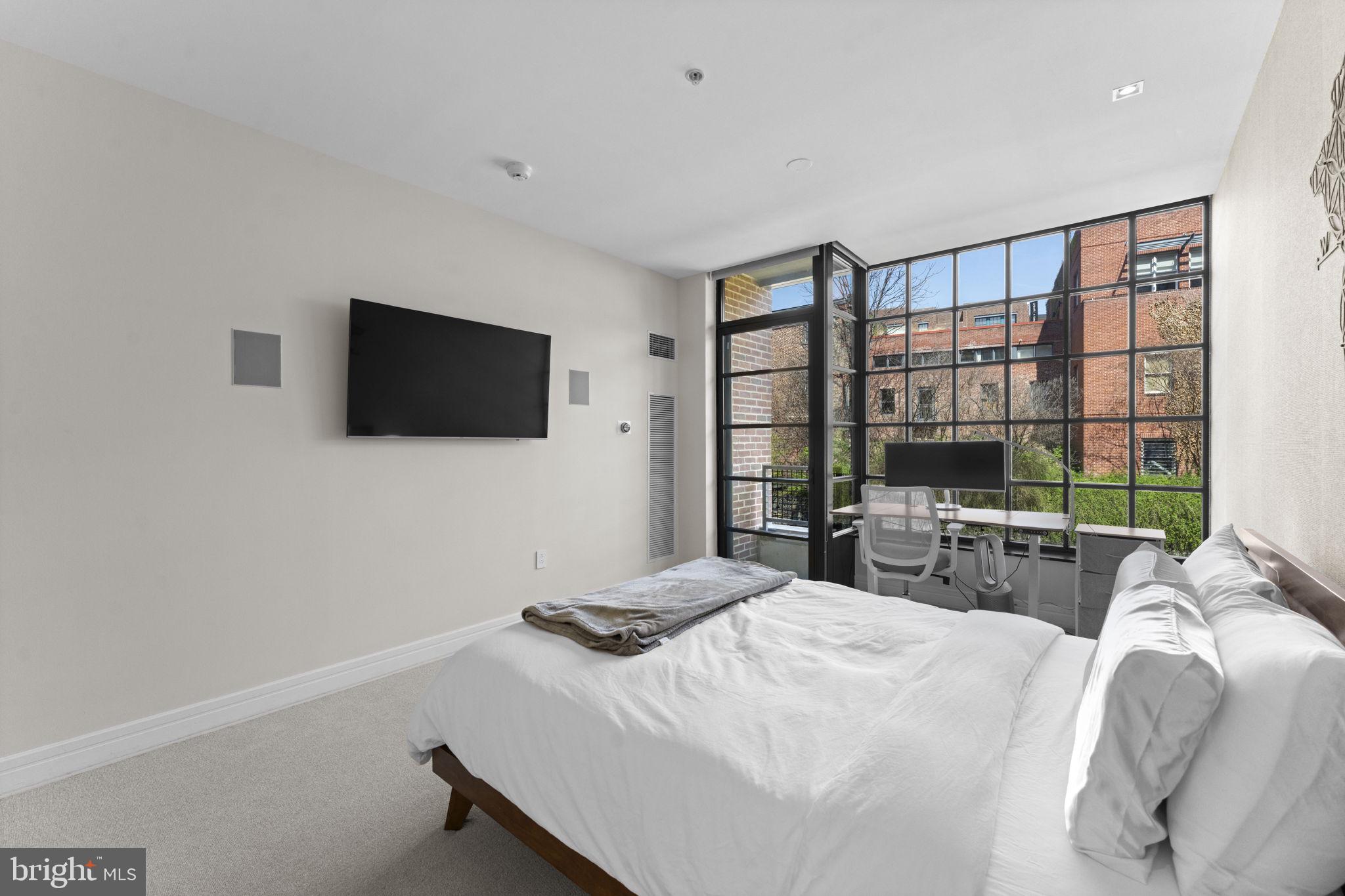 3303 Water Street Northwest, Unit 4B Washington, DC 20007 - Photo 28 of 66 a bedroom with a bed and a flat screen tv