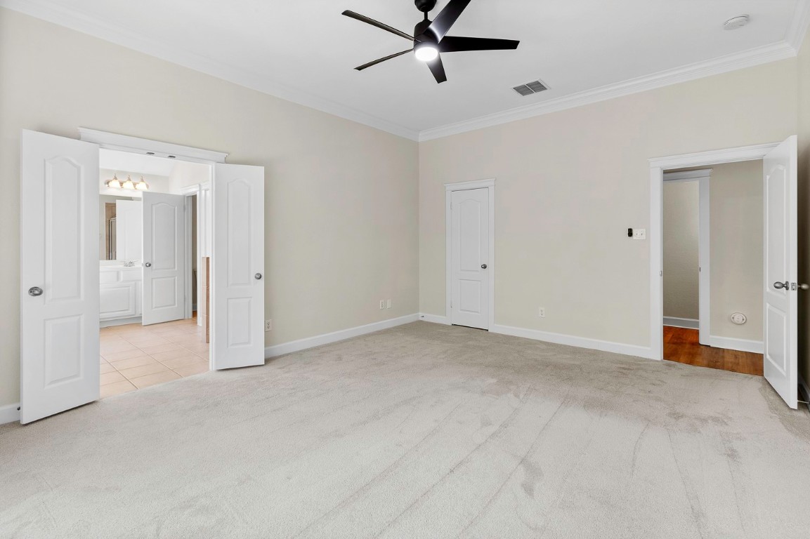 10805 Ariock Lane Austin, TX 78739 - Photo 16 of 40 Unfurnished bedroom featuring ornamental molding, ceiling fan, and light colored carpet