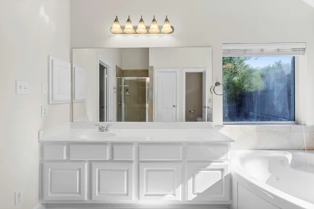 a bathroom with a sink a large mirror and a bathtub