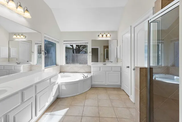 a bathroom with a tub sink and mirror