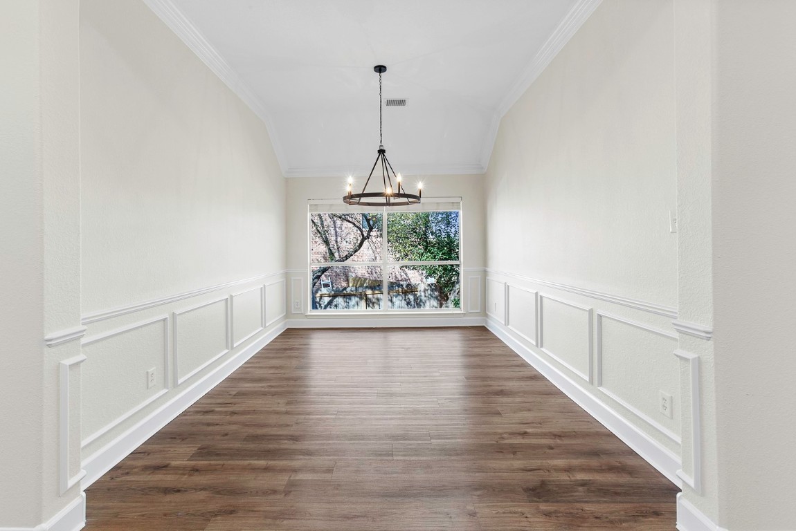 10805 Ariock Lane Austin, TX 78739 - Photo 20 of 40 Unfurnished dining area with a chandelier, dark wood finished floors, and crown molding